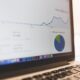 En esta imagen sobre crear eventos en google analytics 4 se ve un portátil mostrando un panel de analítica y gráficos, ideal para ilustrar la configuración de eventos