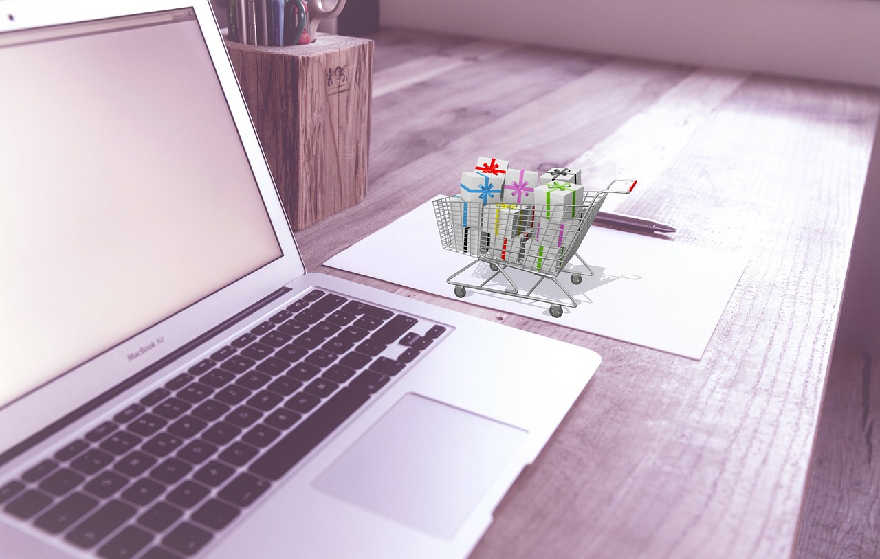Imagen de un portátil con un carrito de compra en una pantalla, ideal para ilustrar el tema para vender en shopify hay que ser autonomo en tu artículo.